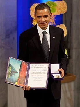 Барак Обама с медалью и дипломом Нобелевской премии