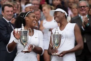 Serena and Venus Williams with Wimbledon doubles trophies